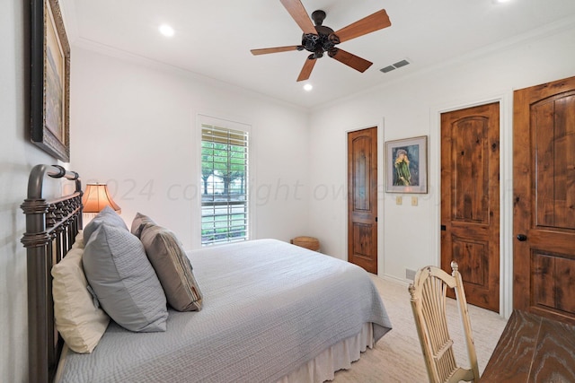 bedroom with ceiling fan, crown molding, light carpet, and two closets