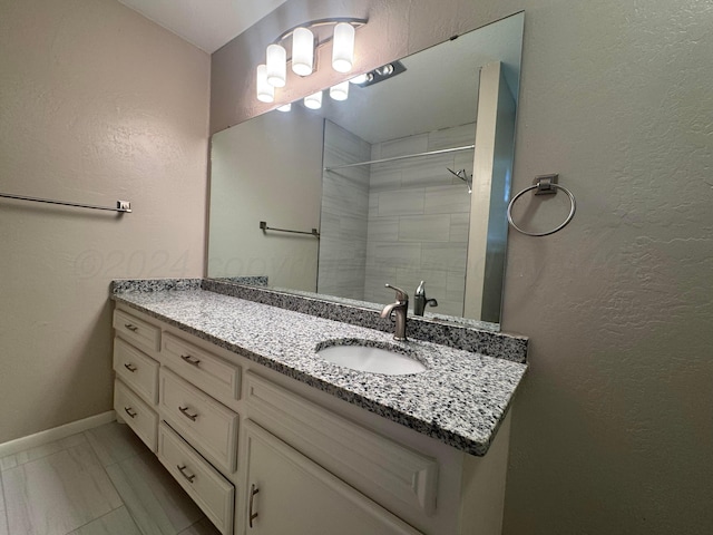3717 Farwell Dr, Amarillo, TX 79109 - bathroom with vanity, a tile shower, marble finish floors, baseboards, and a textured wall