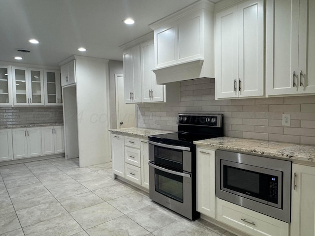 3717 Farwell Dr, Amarillo, TX 79109 - kitchen with appliances with stainless steel finishes, decorative backsplash, white cabinetry, recessed lighting, and glass insert cabinets
