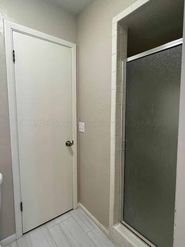 3717 Farwell Dr, Amarillo, TX 79109 - bathroom featuring a shower stall, marble look tiles, and baseboards