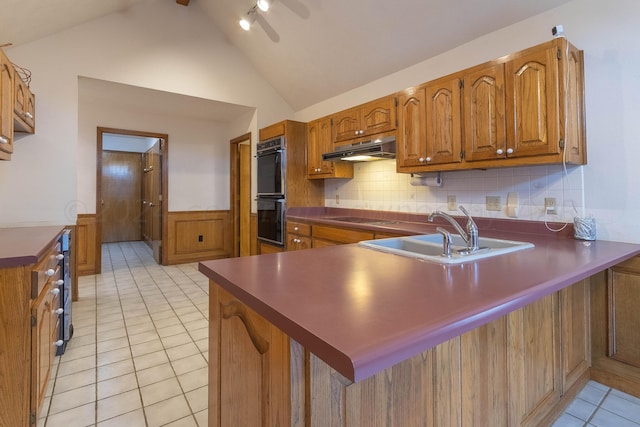 kitchen featuring decorative backsplash, kitchen peninsula, sink, and light tile patterned floors