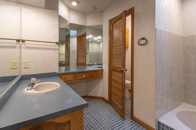 bathroom with a tub to relax in, vanity, toilet, and tile patterned floors