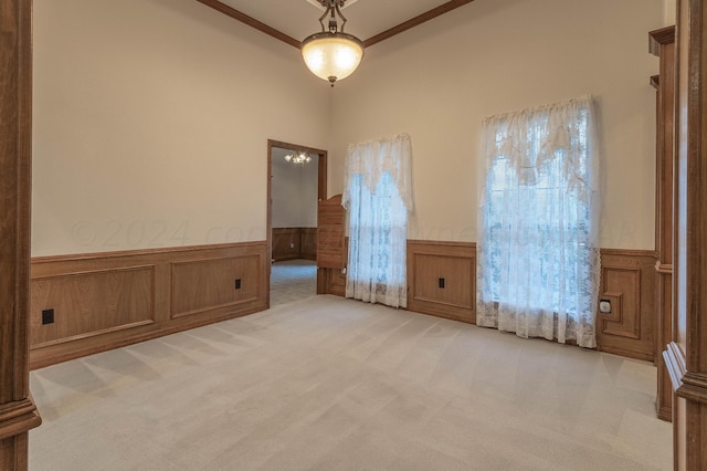 carpeted spare room with wooden walls and crown molding