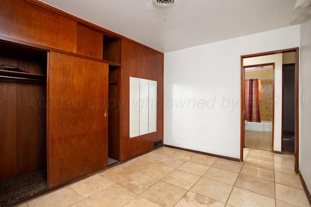 3115 Palm St, Amarillo, TX 79107 - unfurnished bedroom with a closet, light tile patterned floors, and baseboards