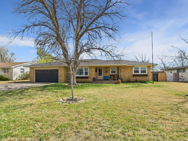 ranch-style home featuring a front yard, brick siding, concrete driveway, and an attached garage