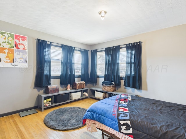 bedroom with hardwood / wood-style floors and baseboards