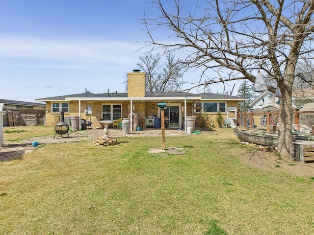 back of property featuring a lawn, fence, a patio, and an outdoor fire pit