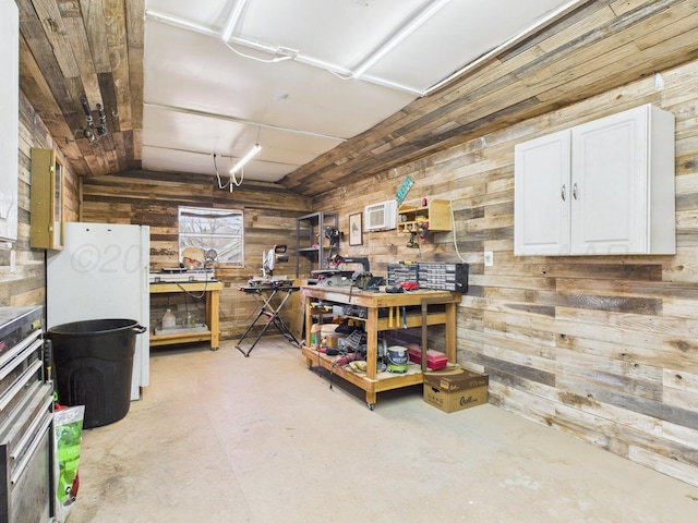 below grade area featuring wood walls, an AC wall unit, and a workshop area