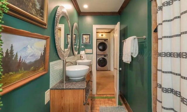 2404 S Harrison St, Amarillo, TX 79109 - full bathroom featuring estacked washer and dryer, crown molding, a shower with shower curtain, double vanity, and tile walls