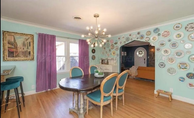 2404 S Harrison St, Amarillo, TX 79109 - dining area featuring ornamental molding, a chandelier, light wood-style floors, baseboards, and arched walkways