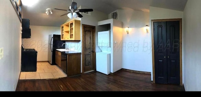 2404 S Harrison St, Amarillo, TX 79109 - kitchen with stacked washing machine and dryer, black appliances, ceiling fan, vaulted ceiling, and light wood-type flooring