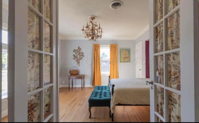2404 S Harrison St, Amarillo, TX 79109 - bedroom with french doors, multiple windows, wood finished floors, a chandelier, and ornamental molding