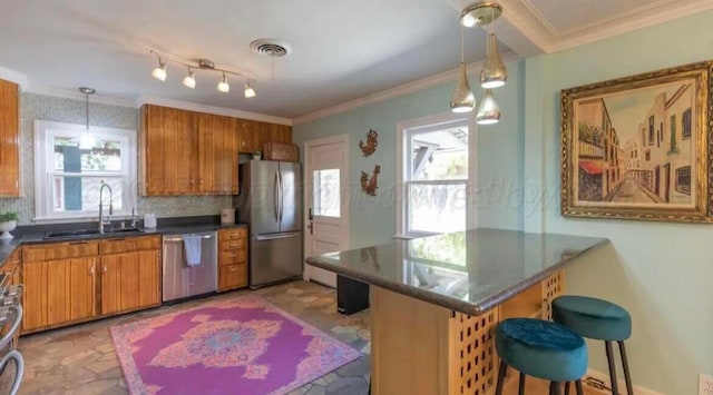 2404 S Harrison St, Amarillo, TX 79109 - kitchen with stainless steel appliances, a sink, dark countertops, brown cabinets, and crown molding