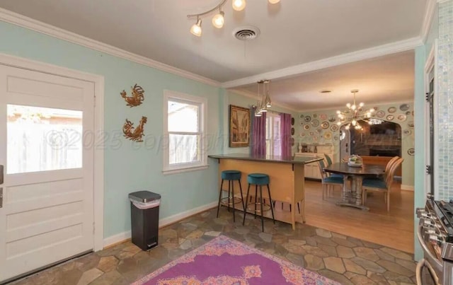 2404 S Harrison St, Amarillo, TX 79109 - kitchen with ornamental molding, a breakfast bar area, a peninsula, a chandelier, and baseboards