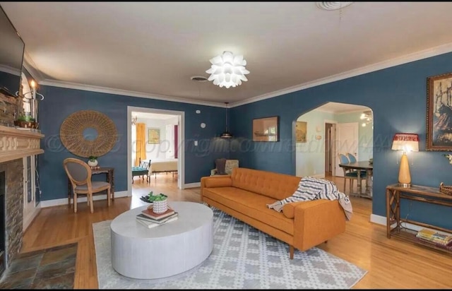 2404 S Harrison St, Amarillo, TX 79109 - living room with arched walkways, wood finished floors, ornamental molding, a high end fireplace, and baseboards