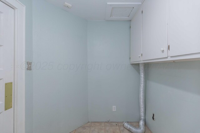 1218 N Charles St, Pampa, TX 79065 - laundry room with cabinet space, attic access, and light tile patterned floors