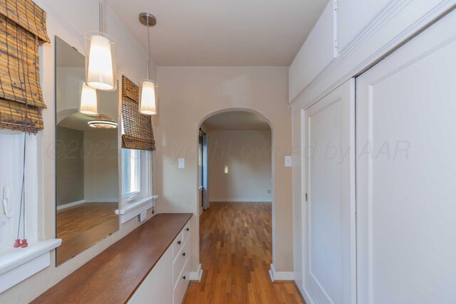 1218 N Charles St, Pampa, TX 79065 - hallway with arched walkways and light wood-style flooring