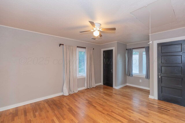 1218 N Charles St, Pampa, TX 79065 - unfurnished bedroom featuring attic access, light wood-type flooring, multiple windows, and a ceiling fan