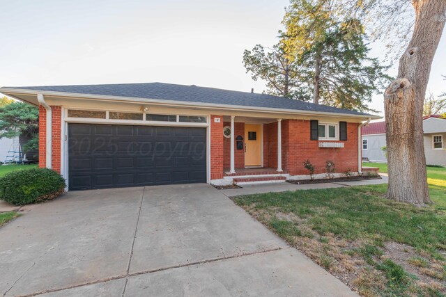 1218 N Charles St, Pampa, TX 79065 - single story home featuring brick siding, concrete driveway, a garage, and a front lawn