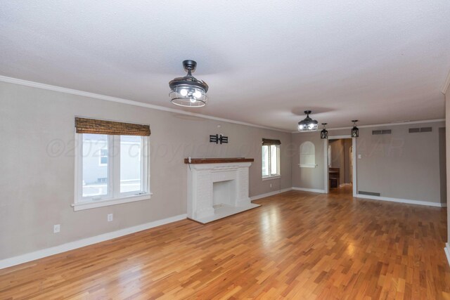 1218 N Charles St, Pampa, TX 79065 - unfurnished living room with light wood-type flooring, ornamental molding, and a brick fireplace