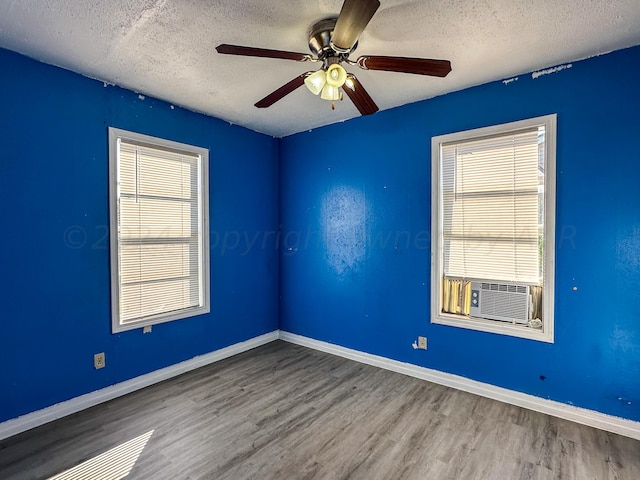 unfurnished room featuring a wealth of natural light, ceiling fan, a textured ceiling, and hardwood / wood-style flooring