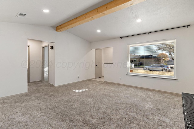 empty room featuring light carpet, a textured ceiling, and vaulted ceiling with beams