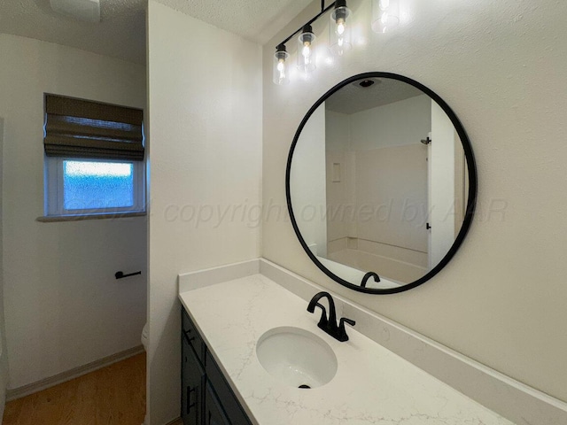 full bathroom with washtub / shower combination, a textured ceiling, vanity, and toilet