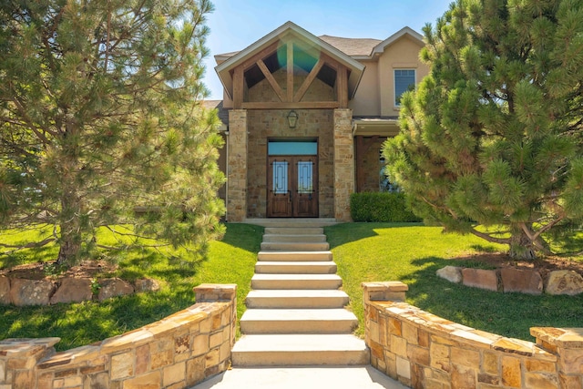 view of exterior entry featuring a yard and french doors