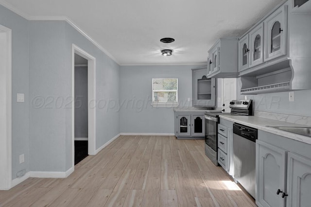 912 W Bonita Ave, Amarillo, TX 79108 - kitchen featuring appliances with stainless steel finishes, light countertops, light wood-style flooring, ornamental molding, and glass insert cabinets