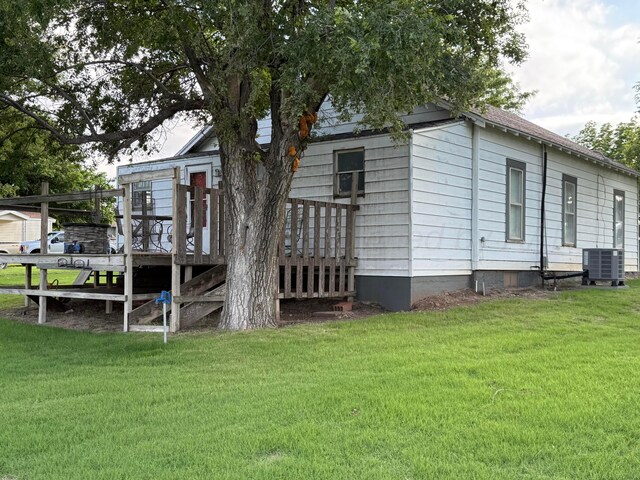 602 S Young St, Follett, TX 79034 - back of property with central AC, a lawn, and a wooden deck