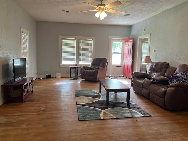 602 S Young St, Follett, TX 79034 - living room featuring a textured wall, ceiling fan, a textured ceiling, and wood finished floors