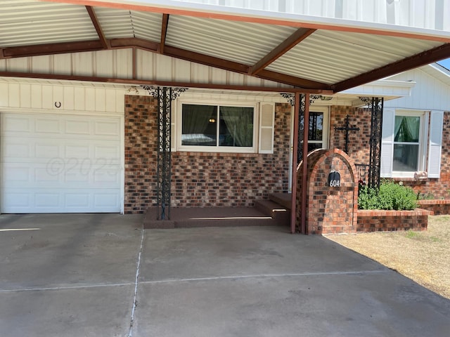 property entrance featuring concrete driveway, a garage, and brick siding