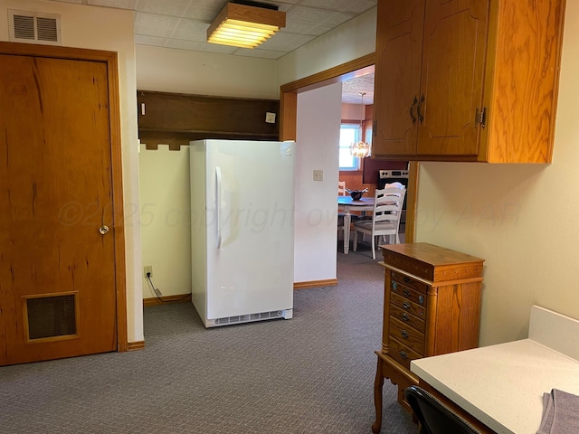 kitchen featuring dark carpet, visible vents, freestanding refrigerator, and a paneled ceiling