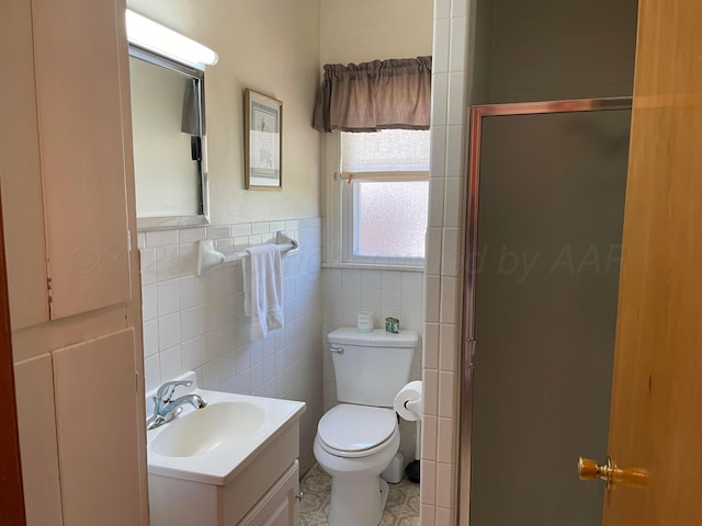 full bath with toilet, tile walls, a shower stall, vanity, and a wainscoted wall
