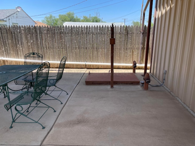 view of patio featuring outdoor dining area and fence