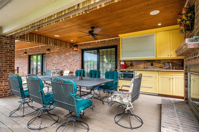 wooden terrace featuring ceiling fan and sink