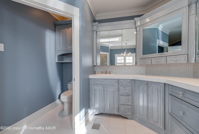 bathroom with decorative backsplash, vanity, tile patterned flooring, a chandelier, and toilet