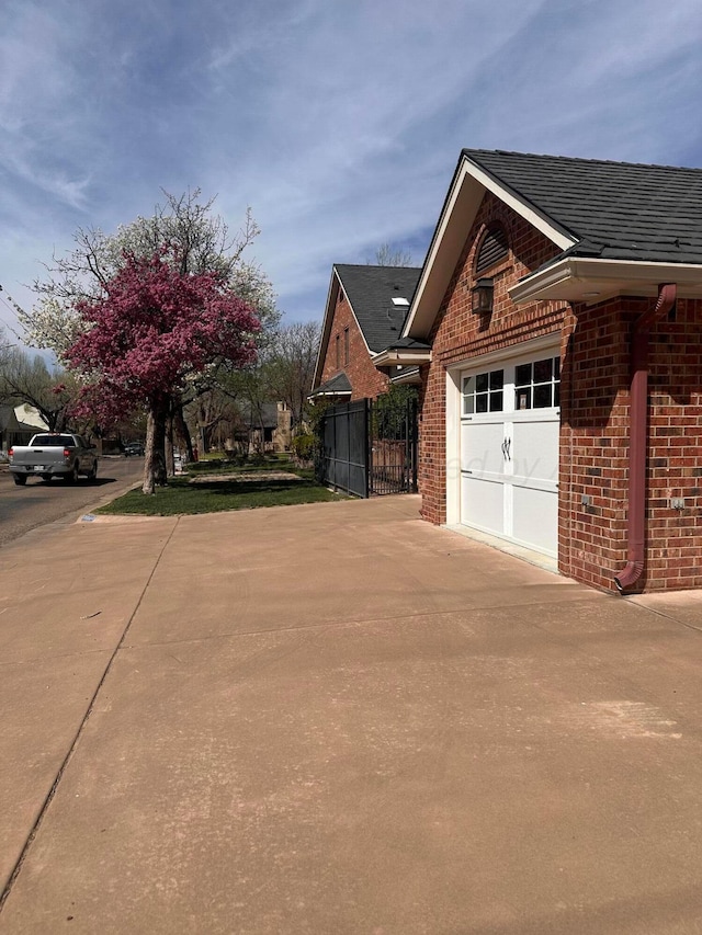 2223 S Ong St, Amarillo, TX 79109 - view of property exterior featuring brick siding, fence, a shingled roof, and driveway