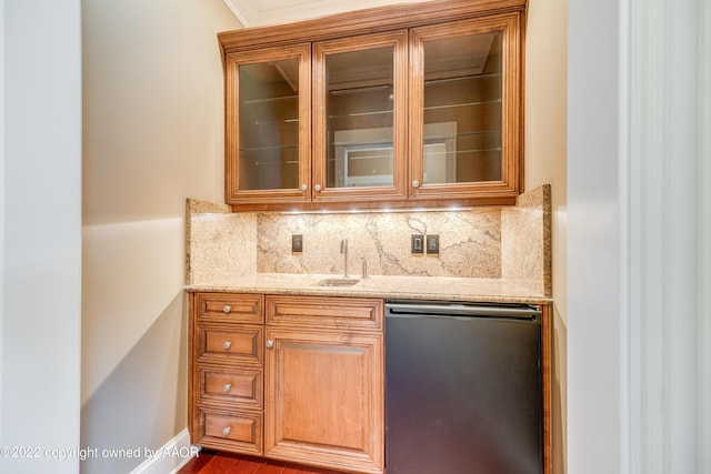 bar featuring backsplash, light stone counters, crown molding, sink, and black dishwasher