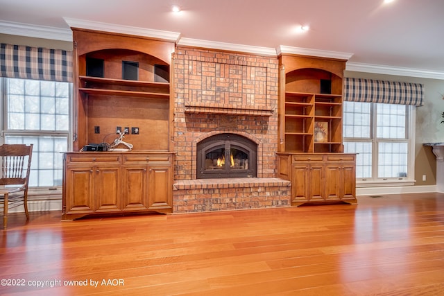 living room with a brick fireplace, light hardwood / wood-style floors, and ornamental molding