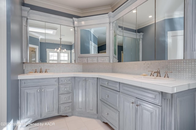 bathroom with tasteful backsplash, crown molding, vanity, and an inviting chandelier