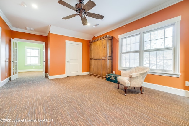 unfurnished room featuring ceiling fan, ornamental molding, light carpet, and a wealth of natural light