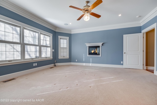 carpeted empty room with ceiling fan and crown molding