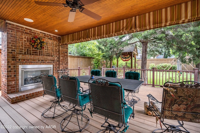 wooden terrace featuring an outdoor brick fireplace and ceiling fan