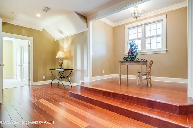 interior space with crown molding, wood-type flooring, vaulted ceiling, and a notable chandelier