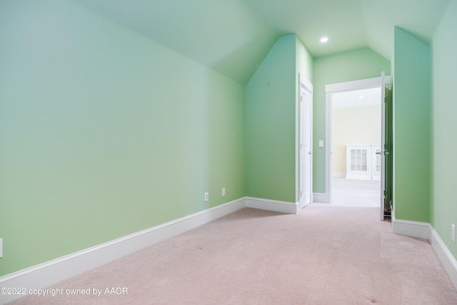 bonus room with light colored carpet and lofted ceiling