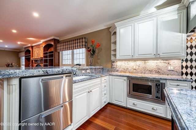 kitchen with white cabinets, stainless steel appliances, kitchen peninsula, and light stone counters