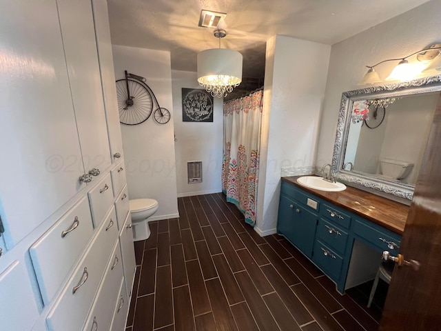 bathroom featuring vanity, a notable chandelier, and toilet