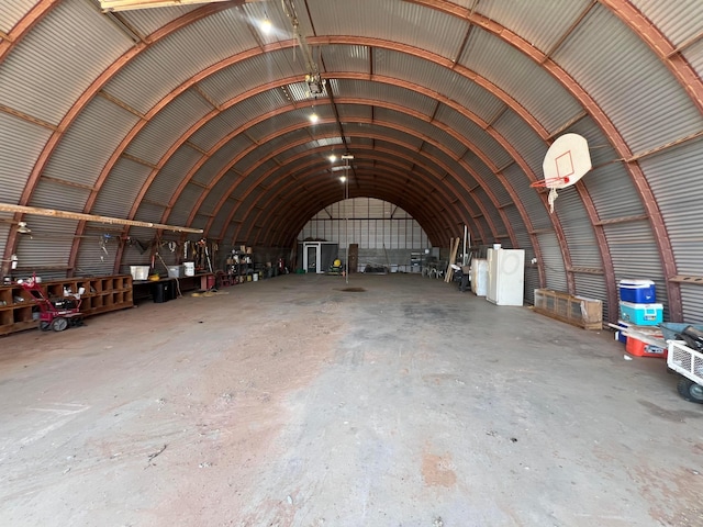 miscellaneous room with vaulted ceiling and concrete flooring