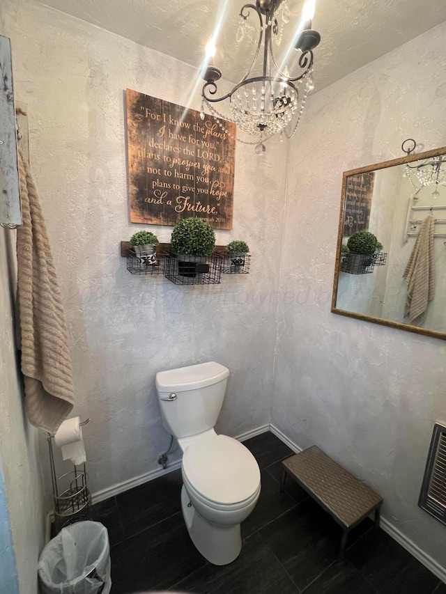 bathroom featuring a notable chandelier and toilet